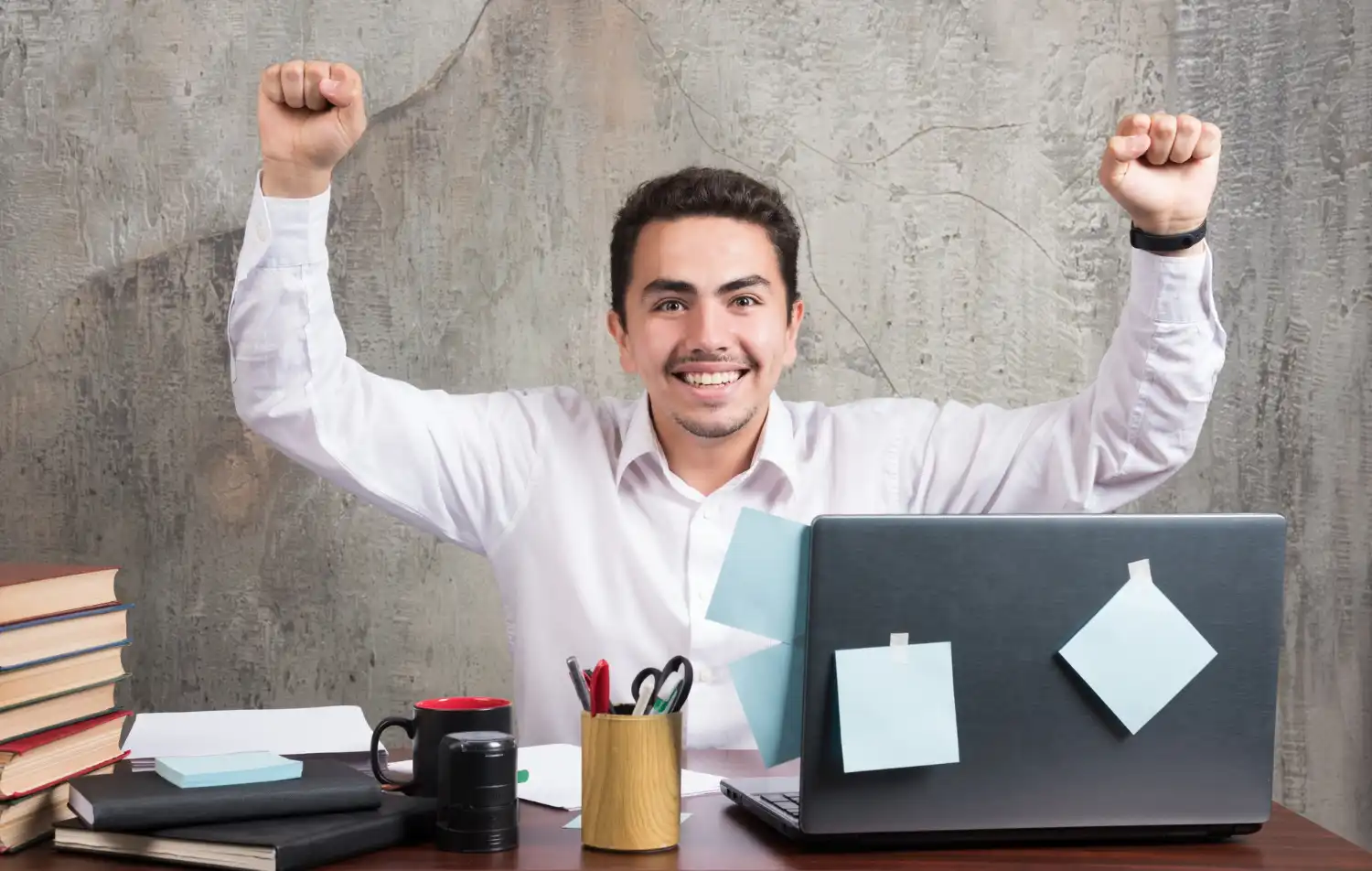 Homem feliz comemorando motivação no trabalho ao final do ano, símbolo de equipe engajada e motivada no último mês do ano.